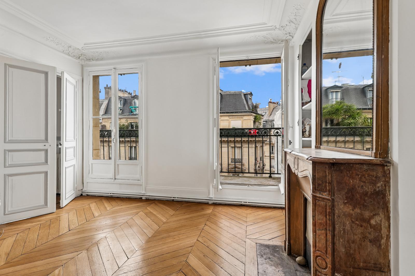 Vue depuis un balcon haussmannien sur les toits de Paris